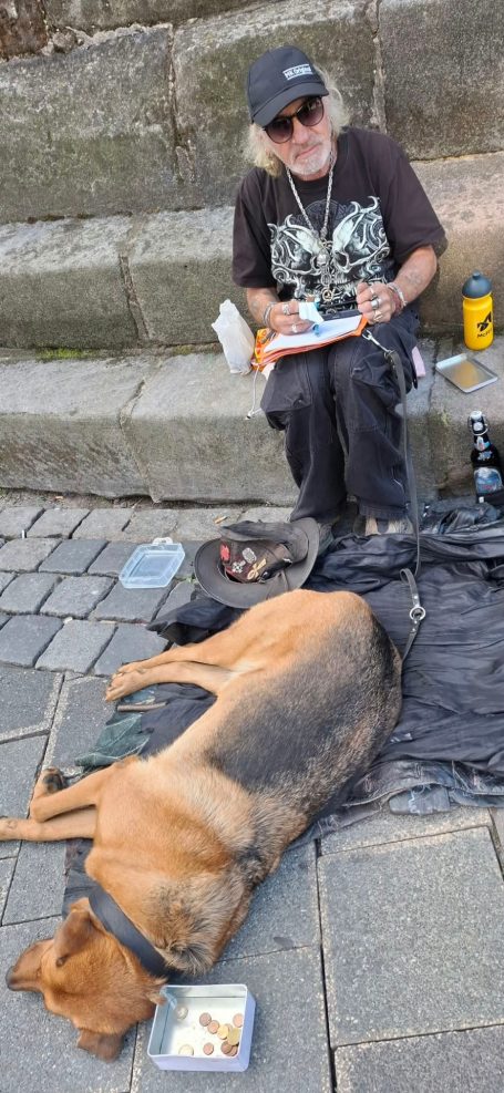 Ein Obdachloser mit seinem Hund Ein Obdachloser mit seinem Hund